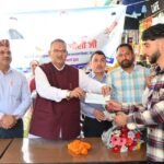 सहस्त्रधारा में आपदा प्रभावित दुकानदारों को सहायता राशि के चैक वितरित करते कैबिनेट मंत्री गणेश जोशी